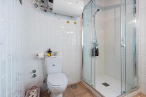 a bathroom with a toilet and a glass shower at Preciosa Casa el Pedroso in El Pedroso +16 photos