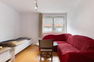 a living room with a red couch and a chair at Yellow in Miltenberg