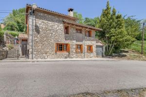 a stone house on the side of a road at Hospitalillo in Sant Corneli de Cercs 