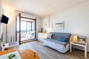 a living room with a couch and a table at Studio Cosy face à l'océan in Lacanau