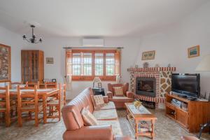 a living room with a couch and a dining room at Villa Padial in Torrox