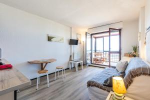 a living room with a couch and a table at Studio Cosy face à l'océan in Lacanau