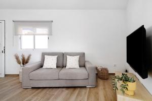 ein Wohnzimmer mit Sofa und Flachbildfernseher in der Unterkunft Flamboyan 2 in Telde