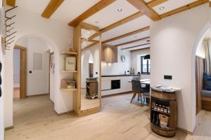a kitchen and living room with wooden ceilings at Bertollhof Weingenuss in Silandro