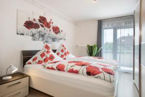 a bedroom with a bed with red flowers on it at Haus Bernhardt in Langenargen