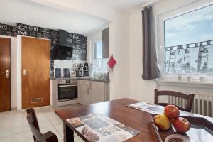 a kitchen with a wooden table and a dining room at Haus Bernhardt in Langenargen