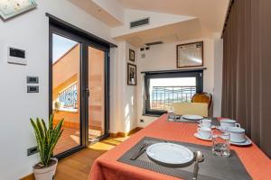 a dining room with a table and a large window at The Amphora Lodging in Furci Siculo