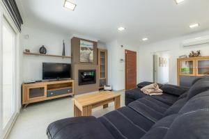 a living room with a blue couch and a tv at Villa Neptuno in Cala Ratjada
