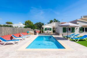 a swimming pool with lounge chairs and a house at Villa Neptuno in Cala Ratjada