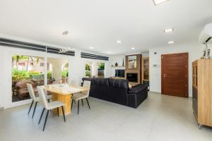 a living room with a black couch and a table at Villa Neptuno in Cala Ratjada