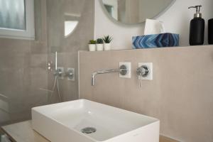 a bathroom with a white sink and a mirror at Lo Ferienwohnung in Friedrichshafen +7 photos