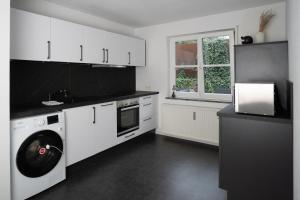 a white kitchen with a washing machine in it at Lo Ferienwohnung in Friedrichshafen