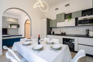 a white dining room with a white table and white chairs at La Domus Firenze in Florence