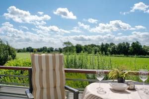 a table with two chairs and a view of a field at Deichblick - in 5 min am Meer in Wangerland