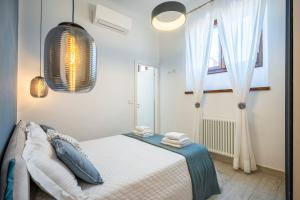 a bedroom with a bed with blue pillows and a window at La Domus Firenze in Florence