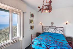 a bedroom with a blue bed and a window at Uliveto in Camogli