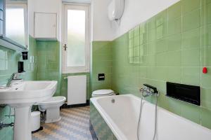 a green bathroom with a sink and a tub and a toilet at Uliveto in Camogli +35 photos