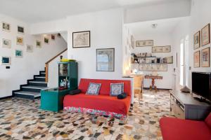 a living room with a red couch and a staircase at Uliveto in Camogli