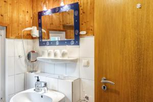 a bathroom with a sink and a mirror at Ferienhaus Strandfloh in Wangerooge +13 photos