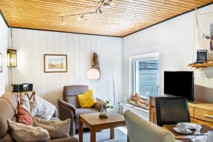 a living room with a couch and a tv at Ferienhaus Strandfloh in Wangerooge