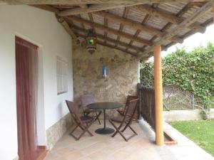 a patio with a table and chairs under a wooden roof at Casas Pepe 7 Bungalow in Los Caños de Meca