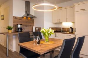 a kitchen with a wooden table with a vase of flowers at Villa Marin Wohnung 1 in Zinnowitz