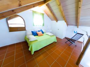 a bedroom with a green bed and a chair at Casas Pepe 7 Bungalow in Los Caños de Meca