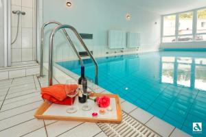 a pool with a table with glasses and a bottle of wine at Villa Marin Wohnung 1 in Zinnowitz