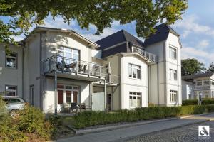 a large white house with a black roof at Villa Marin Wohnung 1 in Zinnowitz