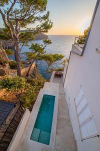 a house with a swimming pool next to the ocean at Ponent in Port de Soller