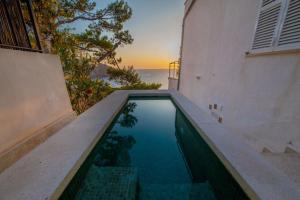 a swimming pool in front of a house with the ocean at Ponent in Port de Soller +10 photos
