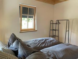 a bedroom with a bed and a window at Ferienwohnung 'dahoimelig' in Friesenried