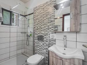 a bathroom with a sink and a toilet and a shower at Andromaches sea view studio 3 in Corfu +17 photos