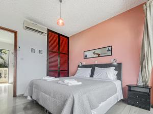 a bedroom with a bed and a pink wall at Andromaches sea view studio 3 in Corfu