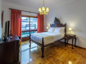 a bedroom with a bed and a television and a window at Villa Vez in Arcos de Valdevez