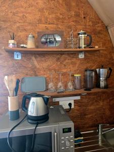 a kitchen with a microwave on top of a stove at La Cabane aux Chevaux in Varages