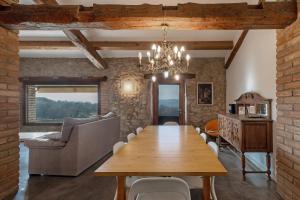 a dining room with a table and a couch at El Baluard De Ferreres in Olvan
