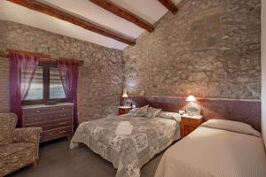 a bedroom with a bed and a chair at El Baluard De Ferreres in Olvan +34 photos
