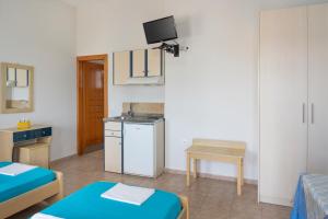 a small room with two beds and a kitchen at Studios Ninemia Serifos 1 in Livadi