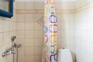 a shower with a colorful shower curtain in a bathroom at Studios Ninemia Serifos 1 in Livadi