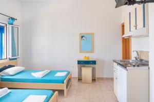 a small room with two beds and a sink at Studios Ninemia Serifos 1 in Livadi