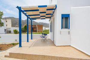 a patio with a blue and yellow canopy on a white house at Studios Ninemia Serifos 1 in Livadi +10 photos