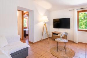a living room with a couch and a tv at Sa Teulera Soller in Sóller