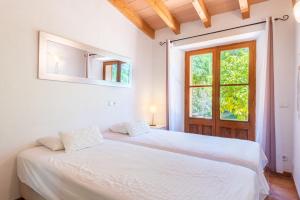 a white bedroom with a bed and a window at Sa Teulera Soller in Sóller +28 photos
