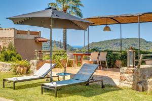 two lounge chairs and an umbrella on a patio at Sa Teulera Soller in Sóller