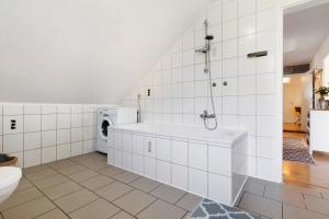 a white bathroom with a tub and a washing machine at Künzes Domizil in Edemissen +16 photos