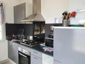 a kitchen with a stove and a counter top at Gîte de Locmousteru in Moustéru