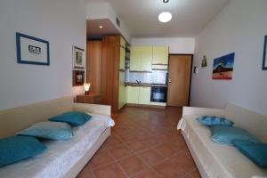 a living room with two beds with blue pillows at Casa Rossana a Otranto in Otranto +21 photos