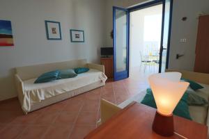 a living room with a bed and a table with a lamp at Casa Rossana a Otranto in Otranto