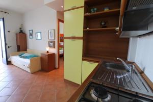 a kitchen with a stove and a room with a bed at Casa Rossana a Otranto in Otranto